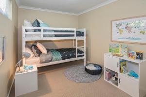 ein Schlafzimmer mit zwei Etagenbetten und einem Schreibtisch in der Unterkunft Ocean Pearls in Busselton