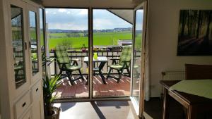 a room with a balcony with a table and chairs at Gästehaus Sonnenhügel in Möhnesee