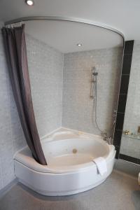 a bathroom with a tub and a shower stall at Royal Exeter Hotel in Bournemouth