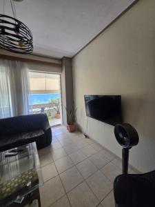 a living room with a couch and a flat screen tv at Kons beach front in Kalamata