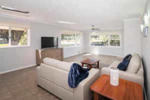a living room with a white couch and a tv at Jetty Views -100m to foreshore in Busselton