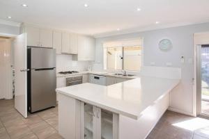 a kitchen with a white counter top and a refrigerator at Jetty Views -100m to foreshore in Busselton