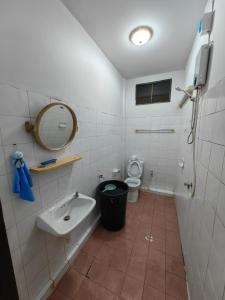 a bathroom with a sink and a toilet and a mirror at K hatyai house in Hat Yai
