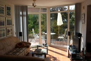 ein Wohnzimmer mit einem Sofa und einer Glasschiebetür in der Unterkunft Zwischen Erfurt, Weimar & Thüringer Wald in Elleben