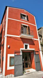 a red building with a window and a balcony at La Perla del Sannio in Sant'Agata de' Goti