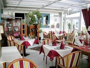 ein Restaurant mit Tischen, Stühlen und roten Servietten in der Unterkunft Wreecher Hof in Putbus