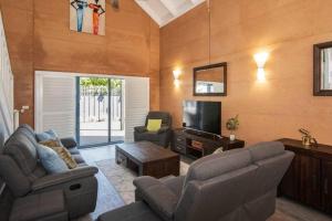 a living room with a couch and a tv at Sea Breeze Villa in Dunsborough