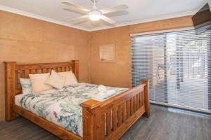 a bedroom with a bed with a ceiling fan and a window at Sea Breeze Villa in Dunsborough