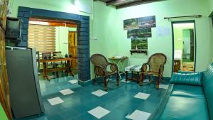 a living room with a couch and a table and chairs at Rose Retreat Homestay in Kottayam