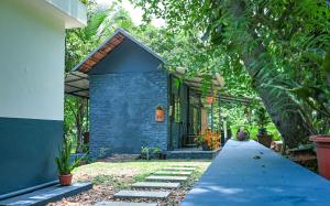 a blue house with a pathway leading to it at Rose Retreat Homestay in Kottayam