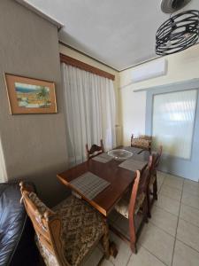 a dining room with a wooden table and chairs at Kons beach front in Kalamata