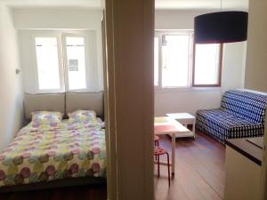 ein Schlafzimmer mit einem Bett, einem Stuhl und einem Tisch in der Unterkunft Studio La Reine Astrid in Antibes