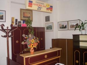 Una habitación con una mesa con un jarrón de flores. en Stop Panzio en Debrecen