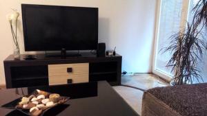 a living room with a flat screen tv on a entertainment center at Hello Apartment in Skopje