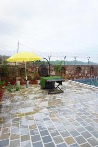 a patio with a table and an umbrella at Bhanwar villa home stay in Udaipur