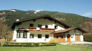 a white house with a mountain in the background at Frühstückpension Larson in Bad Hofgastein