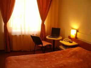 a hotel room with a bed and a laptop computer on a table at Hotel Astoria Standard in Iaşi
