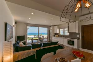 a living room with a couch and a table at Lidia Beach Suites in Kokkinos Pirgos