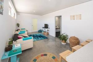 a living room with a couch and a table at Beach Bum Bungalow 2- WIFI, Short walk to the beach in Busselton