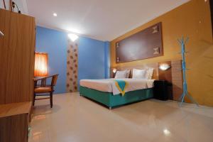 Habitación de hotel con cama y silla en Ancora Syariah Hotel Malioboro by Sawiji, en Ngabean 25 fotos más