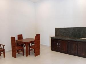 a dining room with a wooden table and chairs at Mivin Villa - Madiha in Godakanda