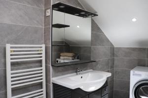 a bathroom with a sink and a washing machine at Appartement 2 chambres in Charleville-Mézières