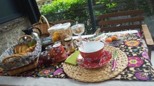 a table with a basket of food and a tea set at Roulotte Mariposa in Loches