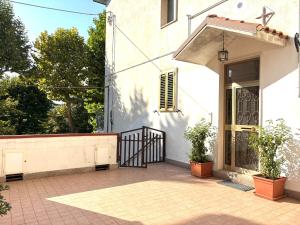 a white building with a gate and potted plants at Casa Pastore 04 in Caramanico Terme