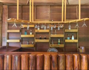 a bar with wooden walls and shelves with vases at Quiet Lodge in Krong Saen Monourom