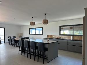 a kitchen with black chairs and a table and counters at Torriciola location Casa Rocca in Propriano