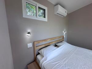 a bedroom with a bed with white sheets and a window at Pangea Stay in Kathu