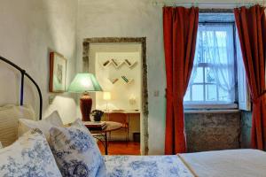 a bedroom with a bed and a window with red curtains at Casa da Belavista in Porto