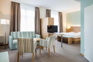 ラウェンブルクにあるHotel Bellevueのベッド、テーブル、椅子が備わるホテルルームです。