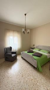 a bedroom with a green bed and a chair at CASA EVA in Celano +19 photos