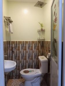 a bathroom with a toilet and a sink at golden anchor lodge in Coron