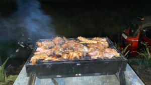 a bunch of chickens and meat on a grill at The wilds Sinharaja in Deniyaya