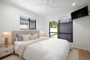 Giường trong phòng chung tại Waterfront Luxury Family Retreat, Noosaville +18 ảnh