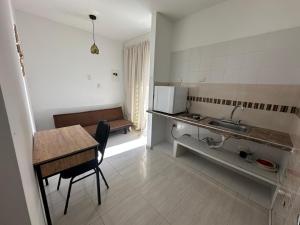 a small kitchen with a table and a sink at HOTEL EBENEZER in Villavicencio