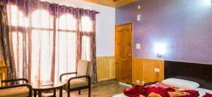 a room with a bed and a table and chairs at Village Live In Resort, Chail in Chail