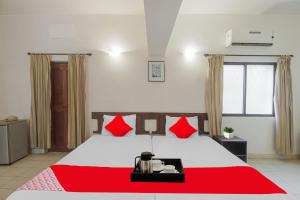 a bedroom with a large bed with red pillows at Hotel O Halcyon Inn in Candolim