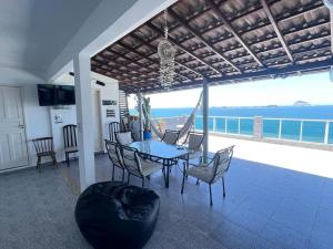 里约热内卢Hostel Vista do Mar的一间有桌子、椅子和大海的餐厅