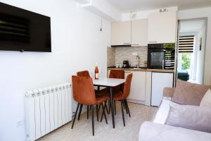 a kitchen with a table and chairs in a room at Twins in Tivat