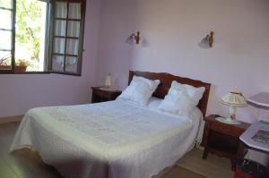 1 dormitorio con 1 cama con sábanas blancas y ventana en Chambres d'hôtes Esponde Marie-Jeanne, en Saint-Jean-le-Vieux