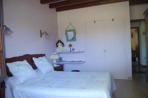 ein Schlafzimmer mit einem weißen Bett und einem Schrank in der Unterkunft Chambres d'hôtes Esponde Marie-Jeanne in Saint-Jean-le-Vieux