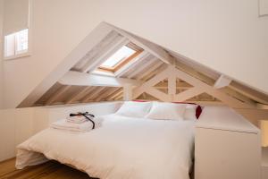 a bedroom with a white bed in a attic at Porto By Heart in Porto