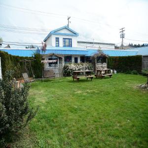 een tuin met twee picknicktafels en een huis bij Bluebird Motel in Port Alberni