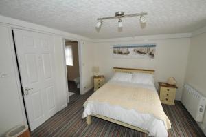ニューキーにあるTreviglos Lodgeのベッドルーム1室(ベッド1台、バスルーム付)