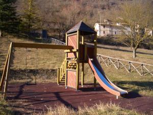 a small playground with a slide in a field at Hotel Ristorante Fiorelli in Preci