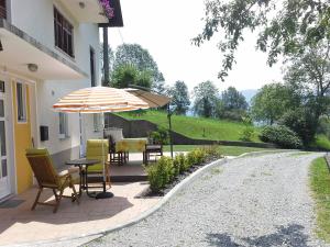 a patio with a table and chairs and an umbrella at Apartment Zadraga in Tolmin
