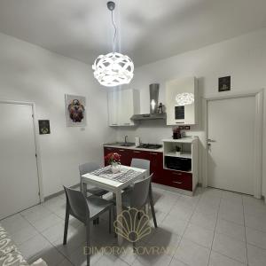 a kitchen with a table and chairs and a light at Dimora Sovrana Gaming Rooms in Matera